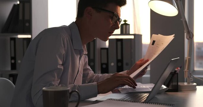 Busy businessman is seen diligently working with a stack of papers. His focused demeanor and organized workspace reflect his dedication to the tasks at hand.