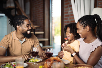 Fototapeta na wymiar Happy black family enjoying in lunch time at dining room