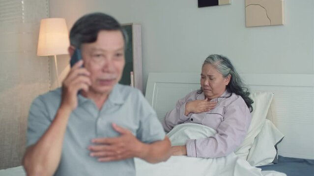 Rack focus of husband calling to ambulance when sitting next to his senior wife with asthma attack in bedroom
