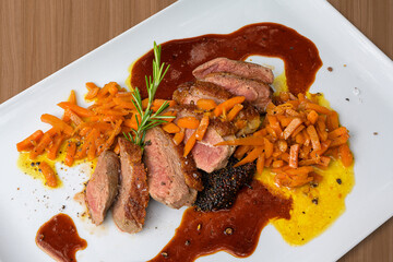 duck breast grilled with orange-carrots on quinoa-taler and orange sauce close up