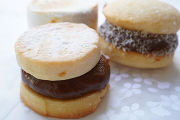 Alfajores (Dulce de leche sandwich cookies) on white background	
