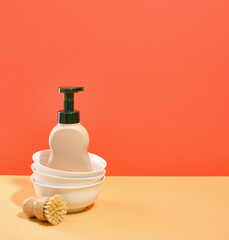 Set of clean washed dishes. Dispenser with detergent. Eco friendly natural brush. Copy space for text.