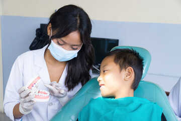 Happy Child in Dentist Office with Female Nurses and Doctors