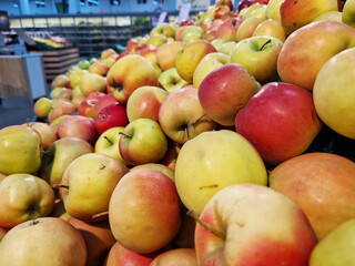 Apples in plastic boxes in a store, close-up. Ripe apples on sale, side view. Sale of fruits