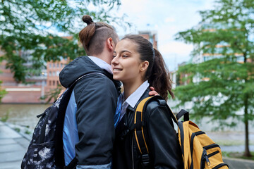 Outdoor teenage friends meeting, hugging on city street