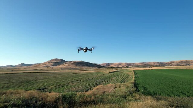 Drone analize agriculture field at sunset, sunrise. Technology used for research analysis, safety, rescue, terrain scanning technology, monitoring soil hydrationand send data to online cloud