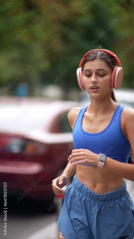 Sticker Running through the urban streets is a young girl in sports clothing and headphones.