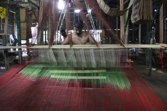 Bangladeshi weaver weaves Benarasi sari (Woman Wear) on a traditional wooden hand weaving loom at Mirpur in Dhaka, Bangladesh. On June 05, 2017 