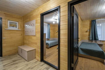 Fototapeta premium empty corridor in interior of entrance hall with many doors in wooden eco house or homestead