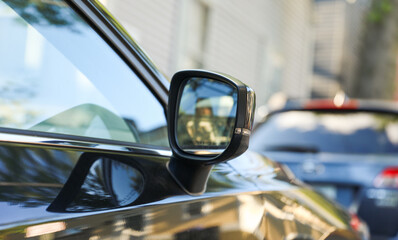 car's rearview mirror, reflecting a scenic road behind. The mirror symbolizes nostalgia,...