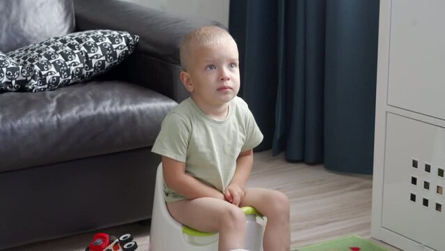 toddler child little boy sitting on a potty in the room