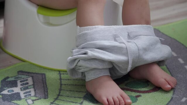 toddler child little boy sitting on a potty in the room