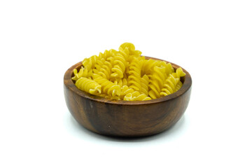 Uncooked Spirellie Fusilli in wooden bowl isolated on white background