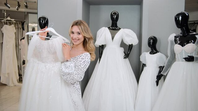 Happy young new bride in bridal store. Smiling woman fall in love in pre wedding day, feeling happy and relax