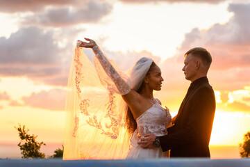 Portrait of newlyweds in the rays of the setting sun