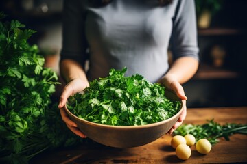 A woman is shown holding a bowl of fresh greens on a table. This image can be used to promote healthy eating and lifestyle choices. - Powered by Adobe