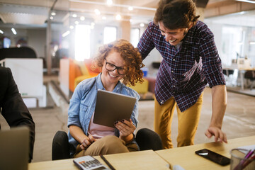 Young Caucasian group of coworkers using the tablet in a modern business office