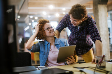 Young Caucasian group of coworkers using the tablet in a modern business office
