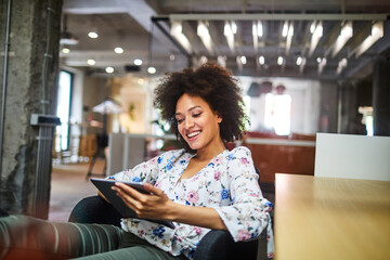 Young African American woman using a tablet in a modern business office