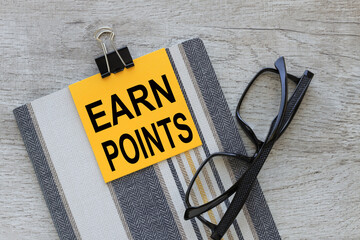 Earn Points. yellow sticker with text attached to notebook