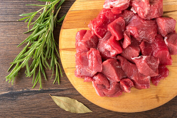 Close-up of raw beef or lamb meat, bay leaf and rosemary.