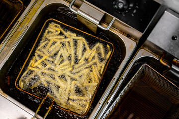 frying potato french fries in hot oil  on kitchen