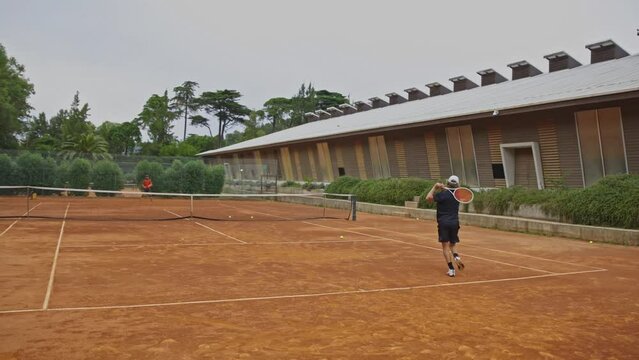 Two young guys play tennis outdoors