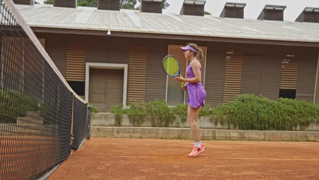 A woman playing tennis on the outdoors court