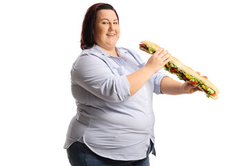 Cheerful corpulent woman in eating a big baguette sandwich