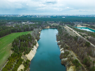 Fototapeta premium Aerial photography of a flooded sand pit from a drone. A sand mine for cement production. Beautiful industrial aeroplane. Mining industry. Mining with the help of a drone and modern technologies.