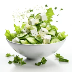 Deurstickers Fresh ingredients for Greek salad falling into bowl on white background © Slanapotam