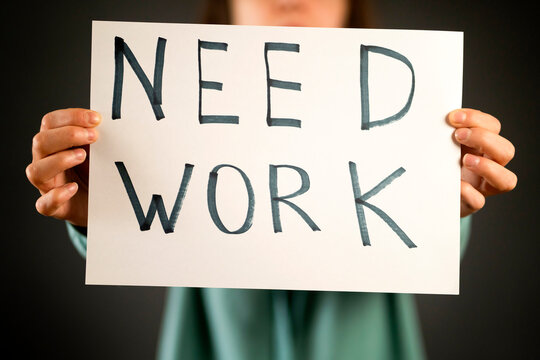 A girl holds a paper with a text "need work" in her hands.