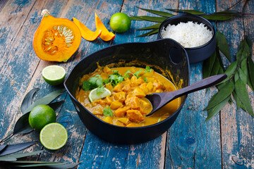 Traditional Indian vegetarian curry stew with sweet potatoes, pumpkin and rice served as close-up in saucepan