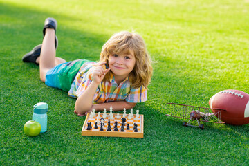 Summer games and outdoor activities for kids. Kid laying on grass enjoy summer lifestyle. Child...