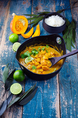 Traditional Indian vegetarian curry stew with sweet potatoes, pumpkin and rice served as close-up...