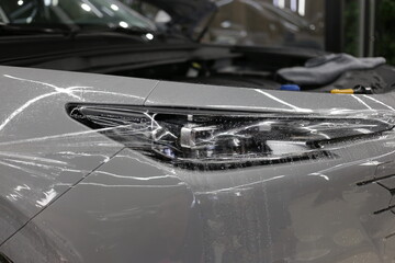 A car wrapping specialist applies a polyurethane film to the car. Selective focus. PPF protective...