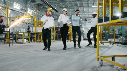 Group of construction engineers having fun and dancing on construction site. Multicultural managers...