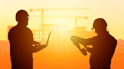 Builders silhouettes. Architects near buildings. Cranes over frames of multi-story buildings. Two...