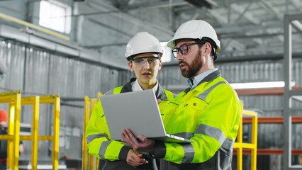Main engineer briskly explains plan of action to employee. Bearded man holding notebook and...