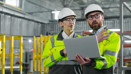Two employees to lead engineers discussing project. People in uniform at workplace. Ethnic...