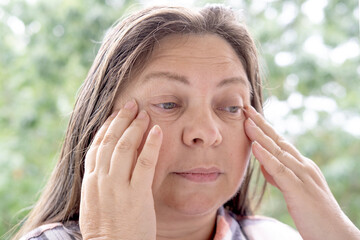 close-up of mature charismatic woman 50 years holding hand over eyes, fatigue syndrome eye, sees poorly, squints, puts on glasses, close up of mature female face, myopia, Vision Correction Options