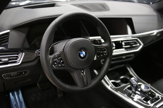 BMW X5 steering wheel and dashboard. Black leather car interior. Vehicle interior SUV car. Car logo. 