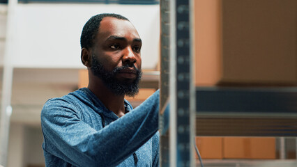African american worker using scanner and tablet to check stock inventory, working on products...