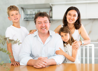 Fototapeta premium Happy family with two children sitting at the table at home