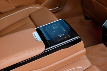Control panel with digital multi color display and knobs for rear seat passenger in modern prestige luxury car interior