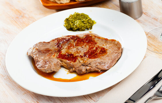Prepared steak of beef with pesto sauce at plate. High quality photo