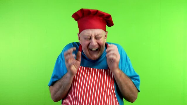 Senior cook in apron hysterically laughing over funny joke.