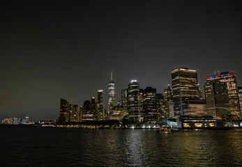 A view of the New York City Skyline as seen from the Staten Island Ferry at night.