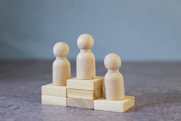 Winners podium from wooden blocks with knobbed cylinders and numbers 1, 2, 3. Hierarchy, ranking...