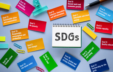 There is notebook with the word SDGs. It is an abbreviation for Sustainable Development Goals as...